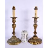 A PAIR OF 19TH CENTURY FRENCH BRONZE ACANTHUS CAPPED EMPIRE CANDLESTICKS decorated with scrolling fo