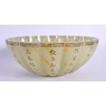 A CHINESE CARVED LOBED JADE BOWL 20th Century, decorated all over with calligraphy. 18 cm wide.