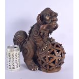 A RARE LARGE 19TH CENTURY CHINESE POTTERY FIGURE OF A BUDDHISTIC BEAST modelled upon an openwork bal