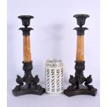 A PAIR OF 19TH CENTURY FRENCH BRONZE AND SIENNA MARBLE EMPIRE CANDLESTICKS formed upon acanthus capp