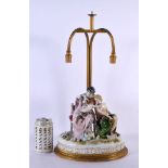 A LARGE EARLY 20TH CENTURY GERMAN PORCELAIN TABLE LAMP formed with figures. 48 cm x 22 cm.
