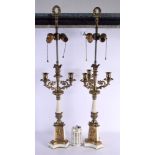 A PAIR OF EARLY 20TH CENTURY BRONZE CANDLESTICKS decorated with putti. 68 cm high.