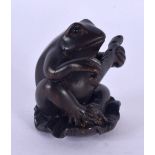A JAPANESE CARVED BOXWOOD TOAD AND FLUTE NETSUKE. 4 cm x 2.5 cm.