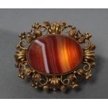 A VICTORIAN BANDED AGATE BROOCH, the oval polished panel solid collet set within a wirework mount,