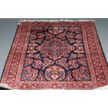A PERSIAN WOOL RUG, modern, the navy blue field with central floral gul surrounded by floral