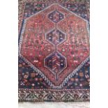 A PERSIAN TRIBAL RUG, modern, the navy blue field with large gul with flowers and animals and