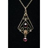 AN EDWARDIAN PENDANT, stamped 9ct, the open lozenge panel centred and hung with two open back collet