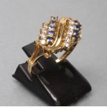A DRESS RING claw set with nine small sapphires and nine small round brilliant cut diamonds