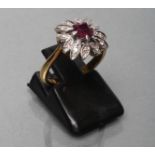 A RUBY AND DIAMOND CLUSTER RING, the square facet cut ruby claw set to a petal border set with