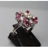 A RUBY AND DIAMOND CLUSTER RING, the seven marquise cut rubies asymmetrically claw set around