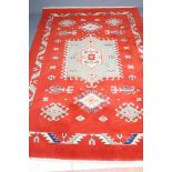 A TURKISH WOOL RUG, modern, the central pale green, red and ivory gul flanked on either side by