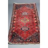 A QASHQAI WOOL RUG, modern, the red floral field with three guls in yellow and navy blue, navy