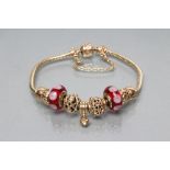 A PANDORA CHARM BRACELET, stamped 585, the rat-tail chain with nine charms comprising an open