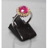 A RUBY AND DIAMOND CLUSTER RING, the brilliant cut ruby of 1.30cts claw set to a border of sixteen