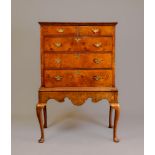 A GEORGIAN WALNUT CHEST ON STAND, early 18th century and later, cross and feather banded, with brass