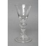 A LARGE WINE GLASS, c.1710, the round funnel bowl on heavy baluster stem with acorn knop and domed