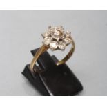 A DIAMOND CLUSTER RING, the central brilliant cut stone of approximately 0.20cts claw set to a