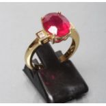 A RUBY RING, the oval facet cut stone of approximately 5.1cts, claw set to square shoulders each