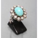A TURQUOISE AND DIAMOND CLUSTER RING, the oval cabochon polished turquoise claw set to a border of