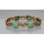 A JADE BRACELET, the six fruit carved square panels with 9ct gold open bow links between, Birmingham