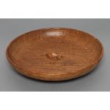 A ROBERT THOMPSON ADZED OAK BOWL, of shallow form with carved mouse trademark in high relief to