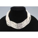 A SEVEN STRAND CULTURED PEARL CHOKER with two diamond set spacing bars to a white oblong clasp