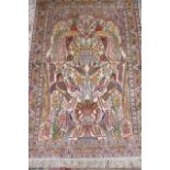 A SMALL PERSIAN SILK RUG, modern, the arched ivory field with exotic birds and vases of flowers in