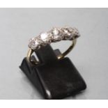A FIVE STONE DIAMOND RING, the old brilliant cut stones claw set to a plain unmarked shank, size