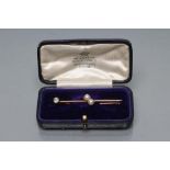 AN EDWARDIAN BAR BROOCH, one end claw set with an old cut diamond of approximately 0.20cts, the
