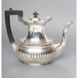 AN EDWARDIAN SILVER HOT WATER JUG, maker's mark HW, Sheffield 1910, of semi fluted rounded oblong