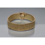 A 9CT GOLD ARTICULATED STRAP BRACELET, with polished upper section and matt lower, the flattened