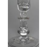 A GLASS GOBLET, c.1710, the plain "U" shaped bowl on a heavy baluster stem with drawn tear, on a
