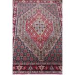 A PERSIAN RUG, modern, the large serrated edged gul in pale blue, red and ivory on a navy blue
