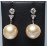 A PAIR OF PEARL DROP EARRINGS, the large spherical pearls peg set to a trefoil claw set with three