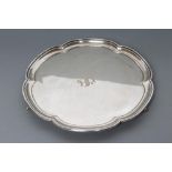 A SILVER SALVER, maker's mark HA, Sheffield 1924, of floriform with pie crust rim, raised upon three