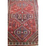 A PERSIAN TRIBAL RUG, modern, the red field with birds and animals and three linked guls in shades