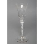 A COMPOSITE WINE GLASS, mid 18th century, the bell bowl engraved with fruiting vines, on a beaded