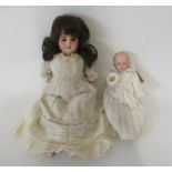 Two bisque socket head dolls, comprising a French girl with brown glass fixed eyes, open mouth and