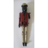 An antique wooden peg doll, with jointed limbs, carved hat, jacket and boots, 9 3/4" long (Est. plus