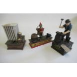 Three cast iron novelty money boxes comprising clown, dog, outside toilet, and blacksmith, some