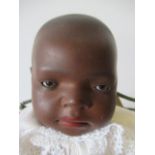 A Heubach Koppelsdorf black baby doll, with brown glass sleeping eyes, painted hair, pierced ears,