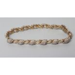 A DIAMOND BRACELET, the fourteen lozenge panels point set with small stones and with fourteen scroll
