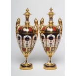 A PAIR OF ROYAL CROWN DERBY CHINA IMARI PATTERN URNS, modern, of slender ovoid form with fixed
