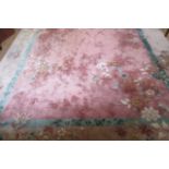 A CHINESE WASHED AND FRINGED RUG, the pale pink field with sprays of flowering branches with