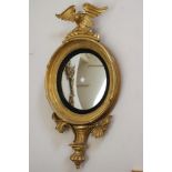 A GILT WOOD CONVEX MIRROR, 19th century, the cavetto frame with reeded ebonised slip and inner