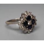 A SAPPHIRE AND DIAMOND CLUSTER RING, centrally set with a small diamond within four sapphires and