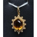 AN EDWARDIAN BROOCH/PENDANT, the facet cut hexagonal citrine within a border of seed pearls on a