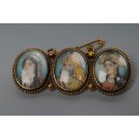 AN INDIAN TRIPLE PORTAIT BROOCH, late 19th century, the small oval ivory panels painted in colours