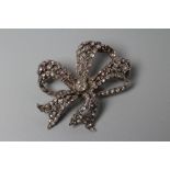 A VICTORIAN DIAMOND BOW BROOCH centred by an old cut stone of approximately 0.4cts and multi stone