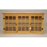 SID POLLARD OF THIRSK, an adzed oak wall display cabinet, the moulded cornice over three glazed